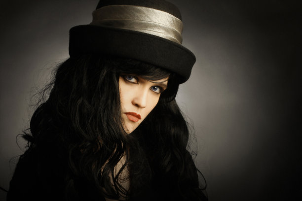 时尚的黑发女人戴着黑色的帽子图片下载