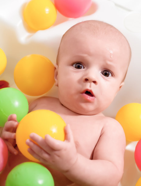 惊喜的小宝贝在用五颜六色的球洗澡图片下载