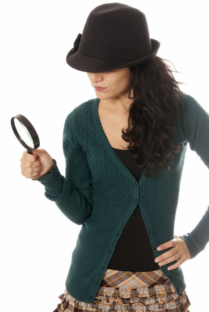 戴着放大镜和帽子的年轻女子在找东西图片下载