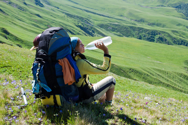 徒步旅行的女孩在草地上休息。图片下载
