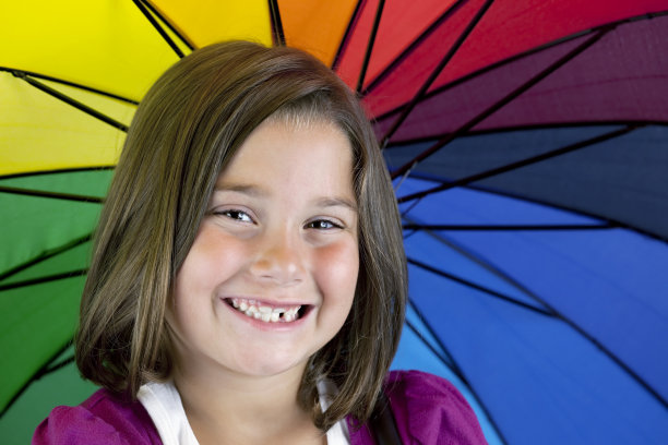 缺牙的年轻女孩和五颜六色的雨伞图片下载