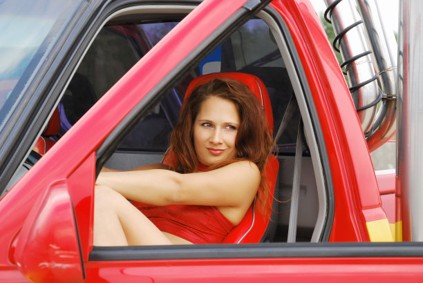 一辆红色轿车里的漂亮女人的特写图片下载
