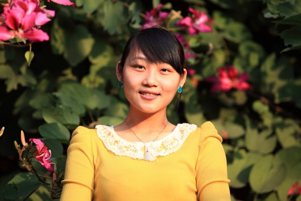 微笑的年轻亚洲女人在自然背景图片下载