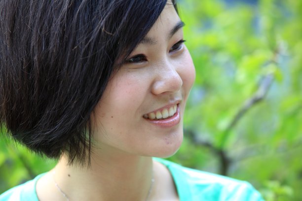 漂亮的年轻女人微笑在室外的花园图片下载