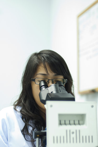 通过显微镜观察的女科学家图片下载