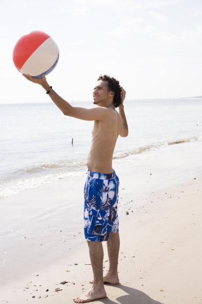 在海边玩沙滩球的男人图片下载