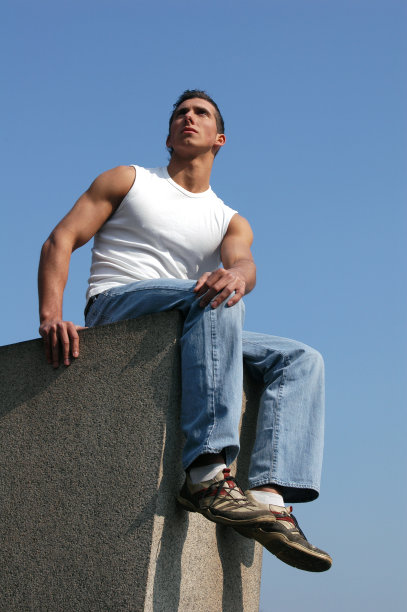 坐在蓝天后面的性感男人图片下载