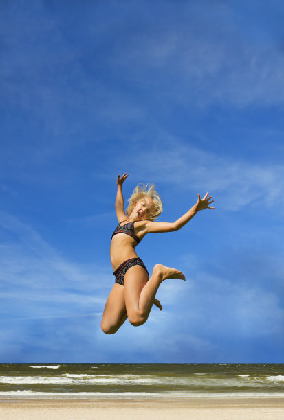 沙滩上蹦蹦跳跳的女孩图片下载