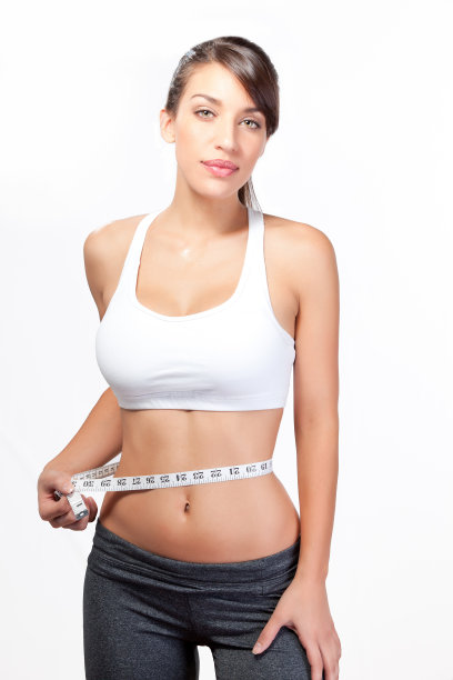 美丽的年轻女子与腹肌测量腰围图片下载