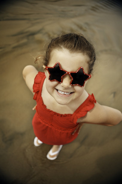 可爱的女孩站在沙滩上图片下载