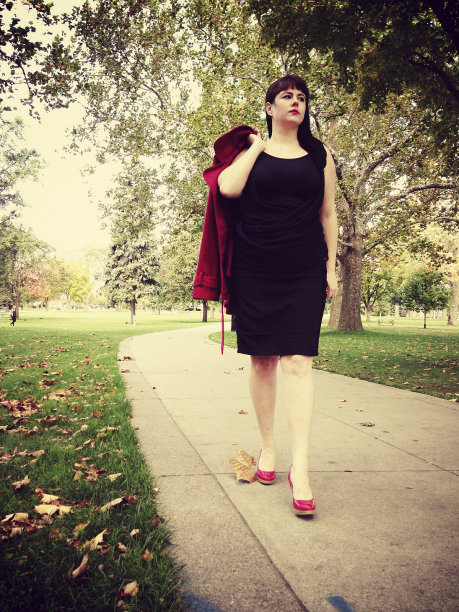 秋天里，女人在公园里散步图片下载