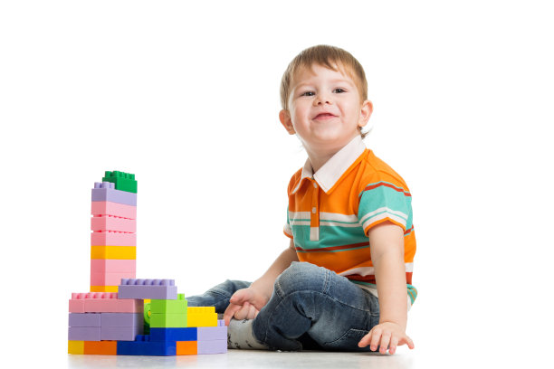 欢快的小男孩在白色背景下玩建筑图片下载