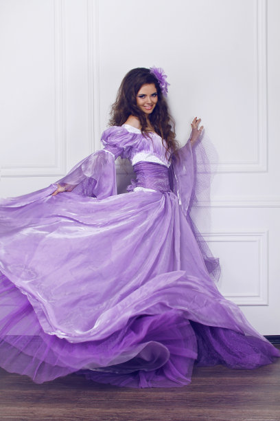 穿着华丽衣服的漂亮女人，靠在墙上图片下载