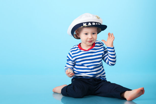 蓝色背景下穿着水手制服的小男孩图片下载