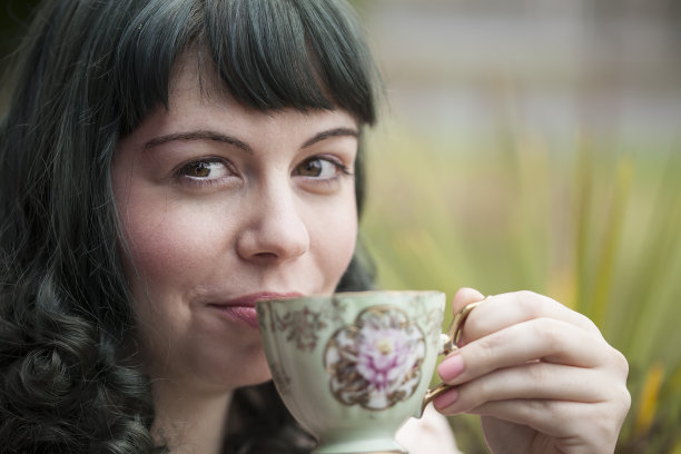 年轻女子与古董茶杯图片下载