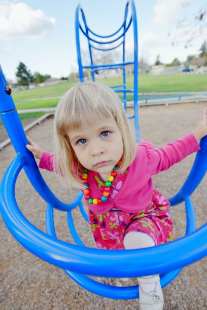 小女孩在操场上爬栏杆图片下载