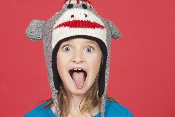 红色背景下女孩伸出舌头的肖像图片下载