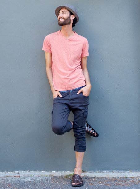 微笑的男人靠在灰色的墙上图片下载