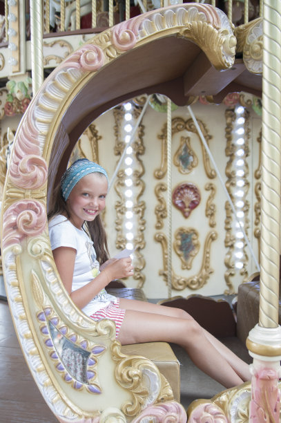 十岁女孩骑着经典的法国旋转木马。图片下载