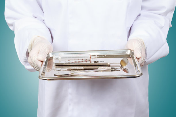 牙医或牙科助理的手。手持牙医工具。图片下载