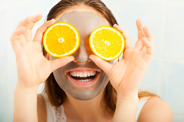 拿着橘片的泥面膜的女人素材图片