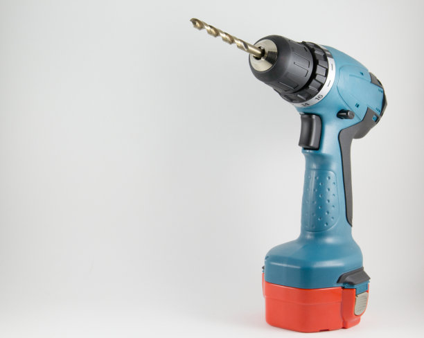 白色背景上带钻的无绳螺丝刀图片下载