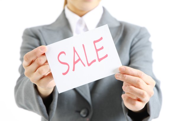 女商人展示一张写着“销售”字样的卡片图片下载