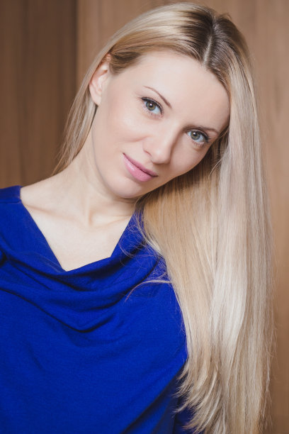 美丽的金发微笑女人的肖像在木制的背景图片下载