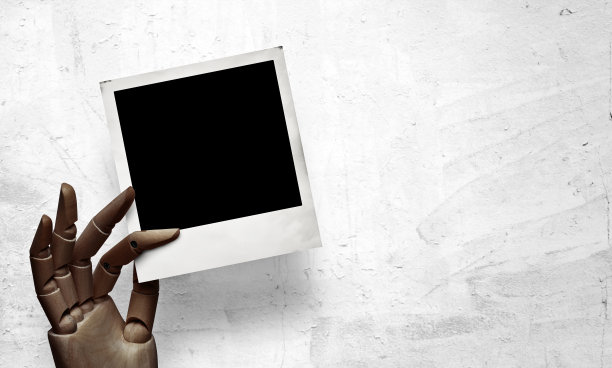 特写的黑木手与宝丽来框架图片下载