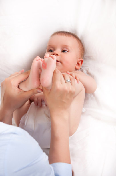 男婴躺在床上，对着妈妈微笑图片下载