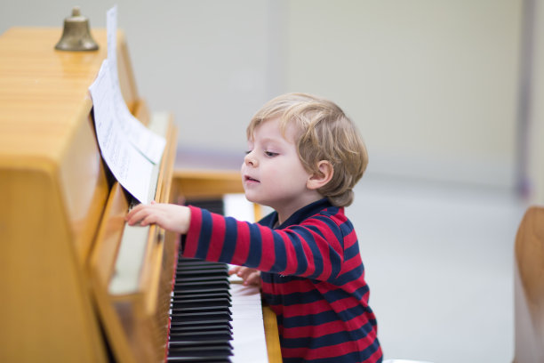 两岁蹒跚学步的男孩在弹钢琴图片下载