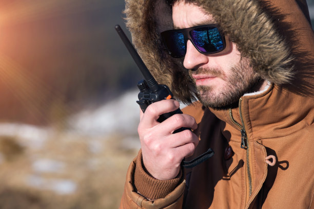 男性徒步旅行者用对讲机对着山峰图片下载