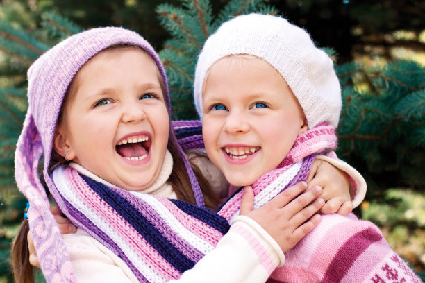 两个女孩在五颜六色的针织衣服拥抱图片下载