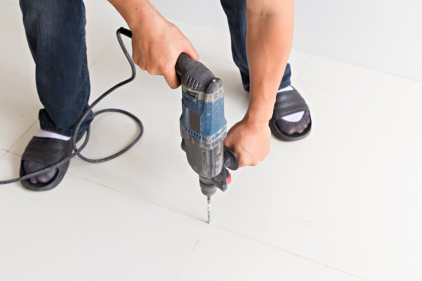 人手持电钻在地板上图片下载
