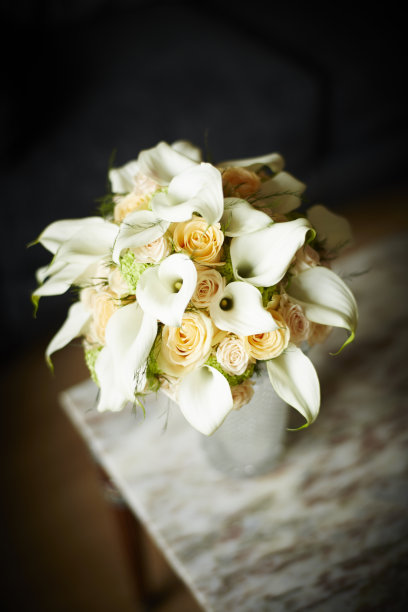 新娘的花束有白色马蹄莲、百合和橙色玫瑰图片下载