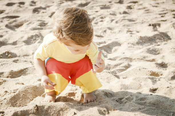 年轻可爱的小男孩在沙滩上玩耍图片下载