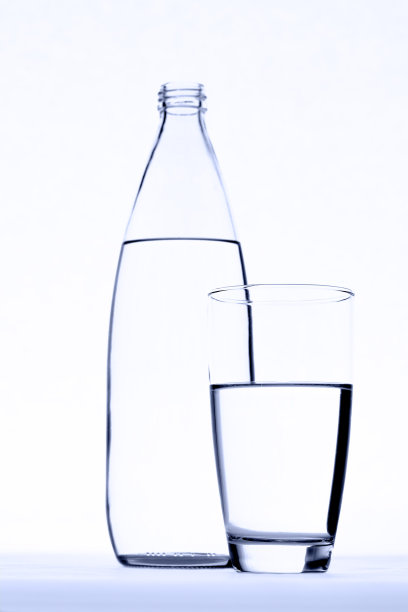 玻璃前面的水瓶孤立在白色图片下载