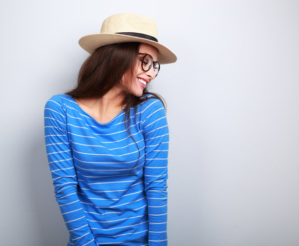 戴着眼镜和草帽向下看的快乐大笑的女人图片下载