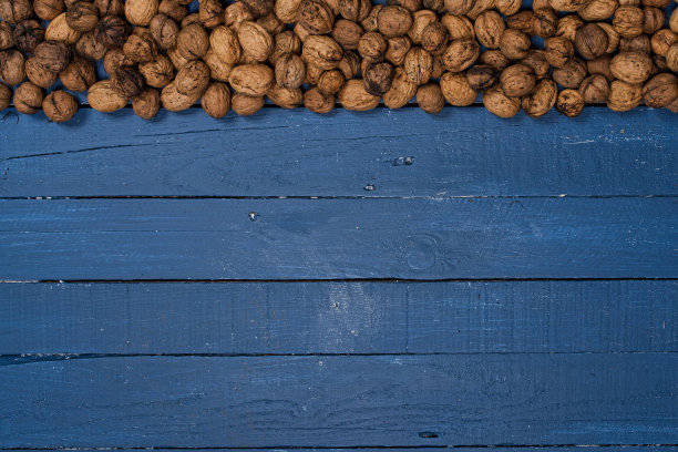 蓝色的木桌上放着核桃图片下载
