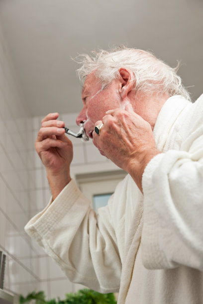 老男人在浴室里刮胡子。图片下载