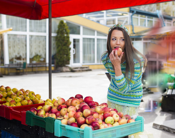 在市场上咬苹果的女人图片下载