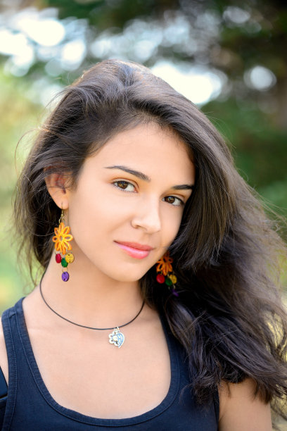 美丽的黑发少女与手工耳环的肖像图片下载