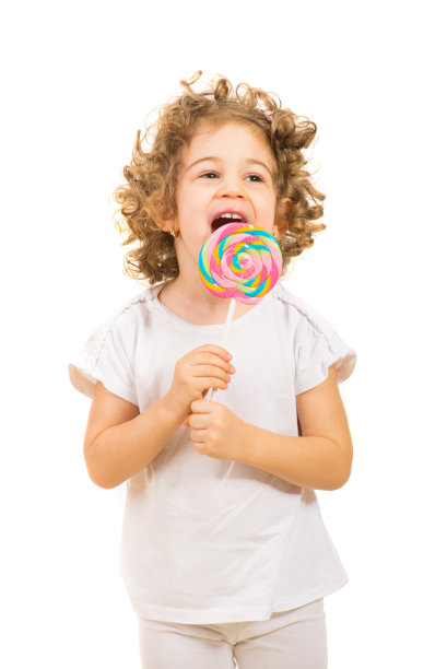 快乐的小女孩舔着大棒棒糖图片下载