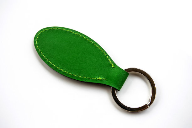 绿色皮革钥匙链隔离在白色背景。图片下载
