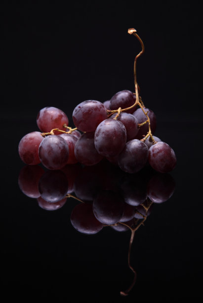 红色葡萄的图像在黑色的背景与反射图片下载