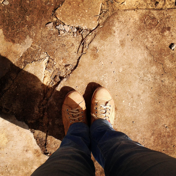 双脚踩在沥青上。图片下载