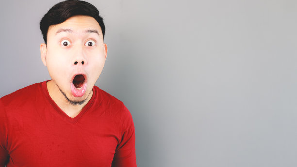 一名身穿红色t恤的亚洲男子感到惊讶和震惊。图片下载