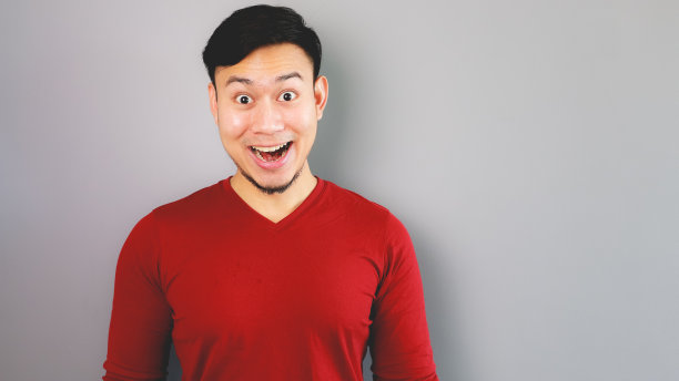 一名身穿红色t恤的亚洲男子感到惊讶和震惊。图片下载