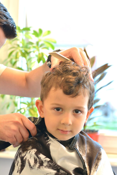 可爱的小男孩在美发师。图片下载
