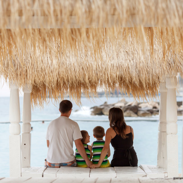 一个幸福的家庭，坐在海滩上，图片下载